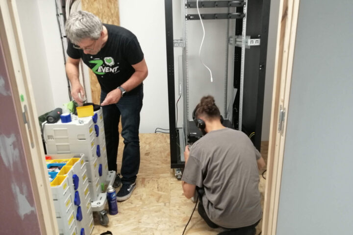 Architecte et ingénieur informatique de Green IT Solutions montant une baie informatique dans le nouveau centre de données à optimisation énergétique de l'entreprise