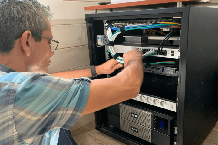 Architecte conseil finalisant l'installation d'une infrastructure dans une mini-baie informatique, aujourd’hui cette solutions complète s'appelle Green Box