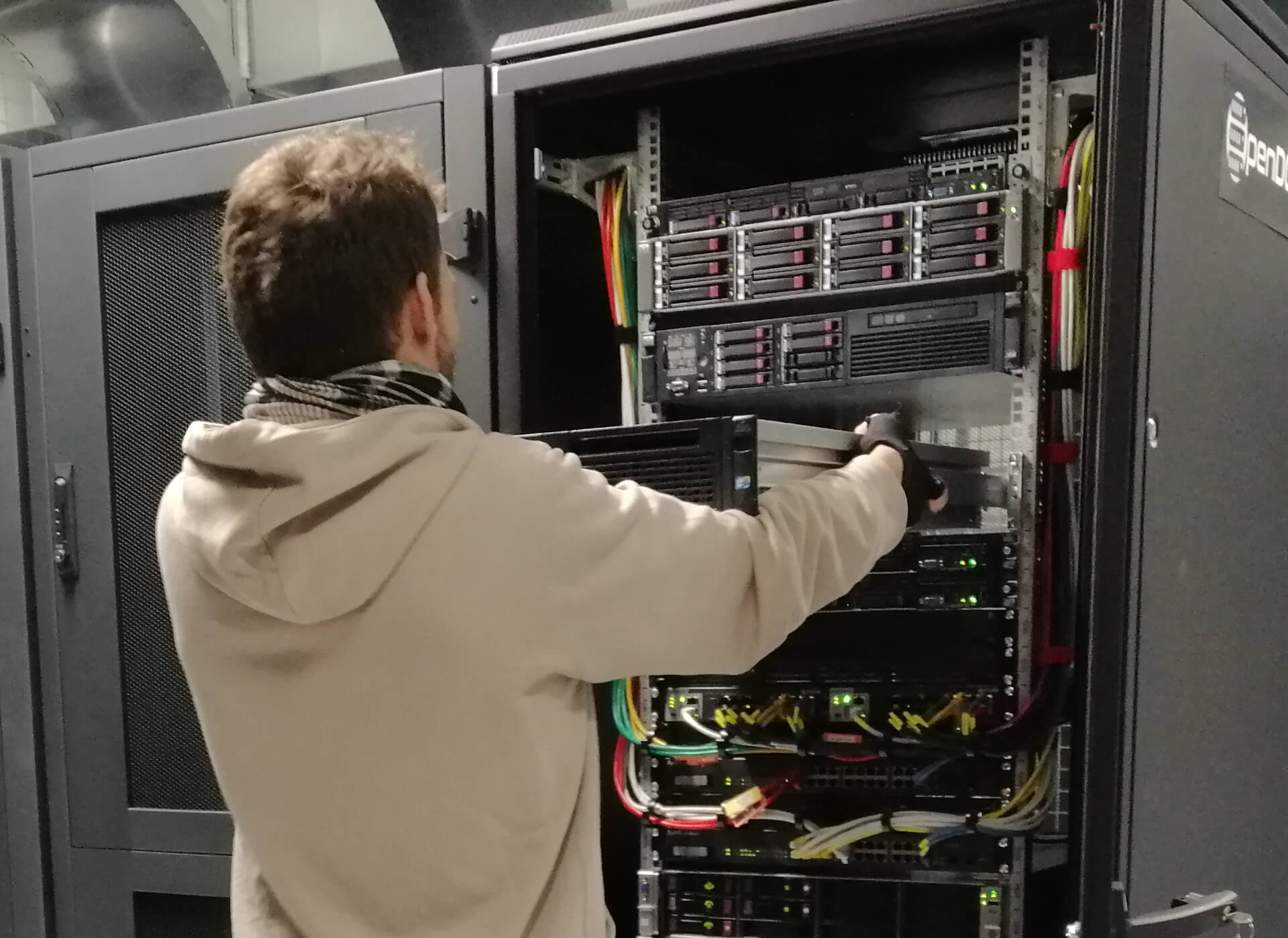 Ingénieur de Green IT Solutions réinstallant un serveur physique dans la baie informatique du datacenter